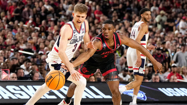 San Diego State University guard Lamont Butler (5) vies for the ball with Connecticut guard Joey Calcaterra (3) during the first half of the men's national championship college basketball game in the NCAA Tournament on Monday, April 3, 2023, in Houston. (AP Photo/Brynn Anderson)