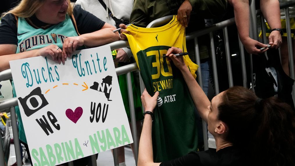 New York Liberty forward Breanna Stewart signs a jersey from her Seattle Storm days before a WNBA basketball game between the Liberty and the Storm, Tuesday, May 30, 2023, in Seattle. (AP Photo/Lindsey Wasson)