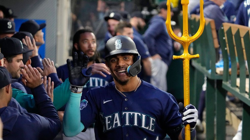 Seattle Mariners' Julio Rodriguez is congratulated by teammates in the dugout while holding a trident after hitting a two-run home run during the third inning of a baseball game against the Los Angeles Angels Saturday, June 10, 2023, in Anaheim, Calif. (AP Photo/Mark J. Terrill)
