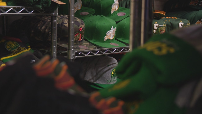 In this photo is a stack of Seattle  SuperSonics hats at sports retail store "Simply Seattle." (KOMO)