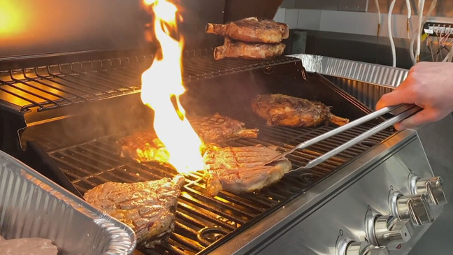 A photo of multiple ribeye steaks being cooked on a propane grill. (Photo: KOMO News via Consumer Reports)